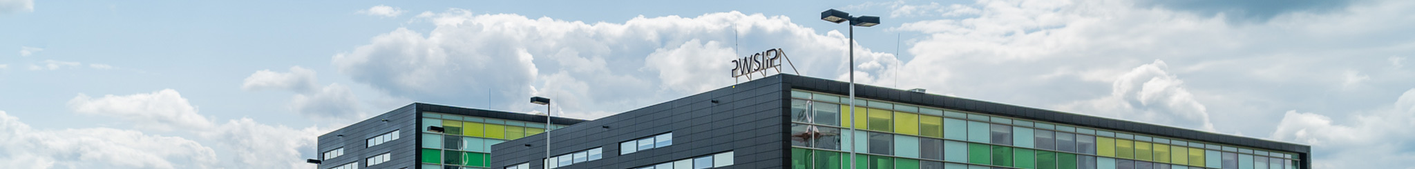 Widok na górną część budynku Akademicka 1, niebo w tle